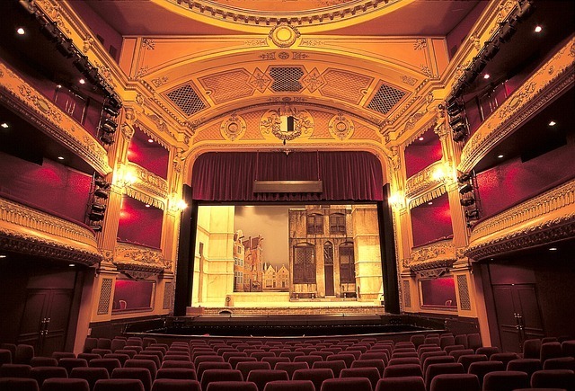 A golden-lit theatre stage and chairs.